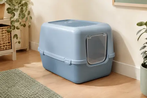 Maison de toilette bleue pour chat avec couvercle amovible et porte battante, dans un intérieur lumineux